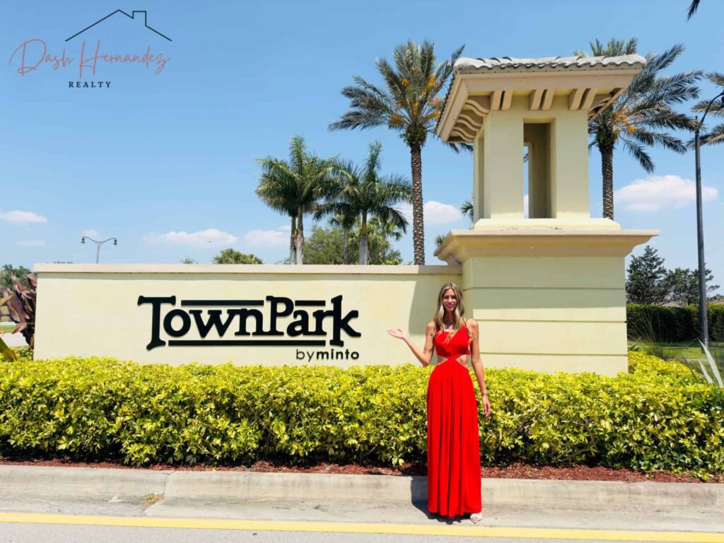 Dash Hernandez Presenta TownPark at Tradition: Vida en Casas Adosadas en Port St. Lucie - Dash Hernandez Dash Hernandez, agente inmobiliaria, en la entrada de TownPark at Tradition en Port St. Lucie, FL.