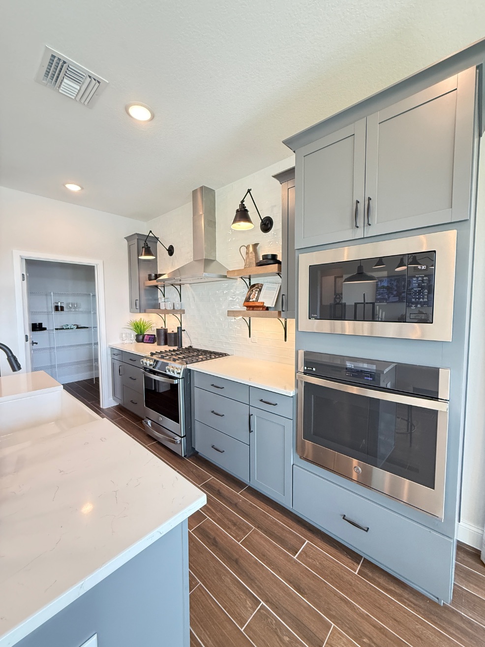 Astaire Model Kitchen | Four Seasons at Wylder K. Hovnanian Astaire Model Kitchen at Four Seasons at Wylder - Modern kitchen with large island and white cabinets by K. Hovnanian in Port St. Lucie, FL