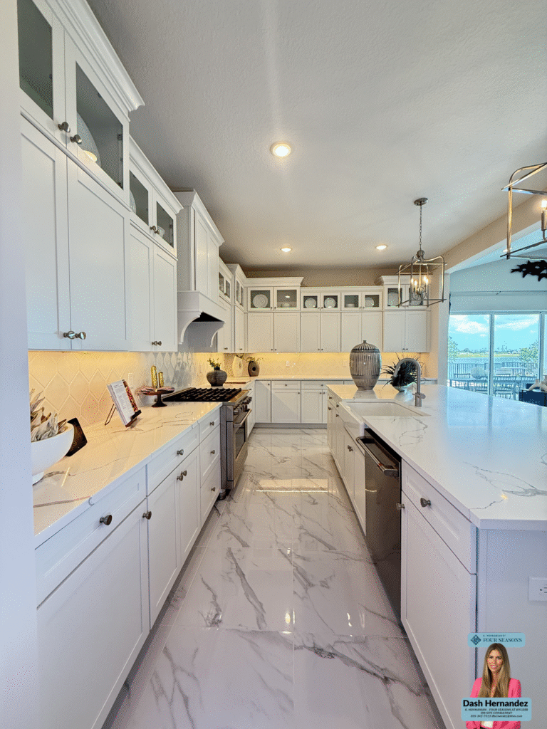 Modern kitchen with white cabinets and marble counters in active adult community in Port St. Lucie
